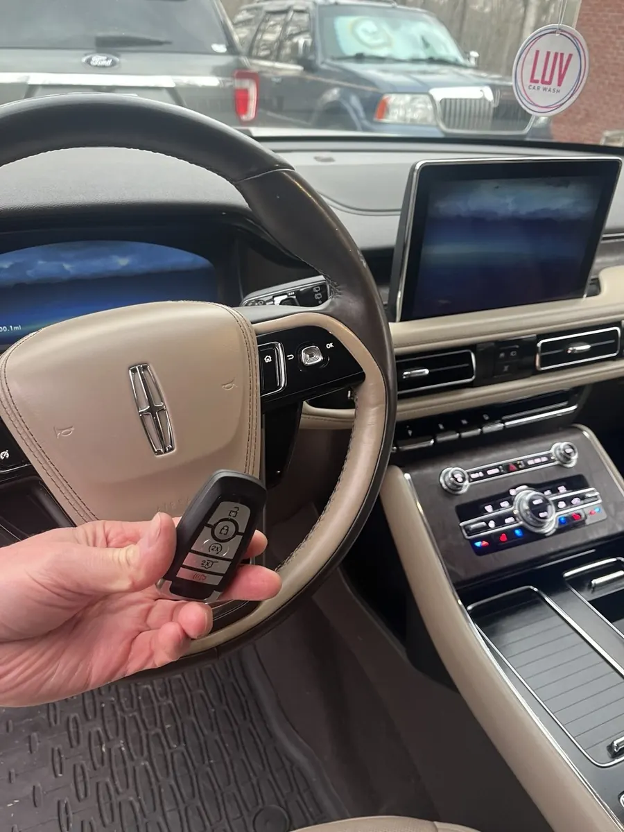 New smart key programmed for a Lincoln SUV, held in front of the steering wheel